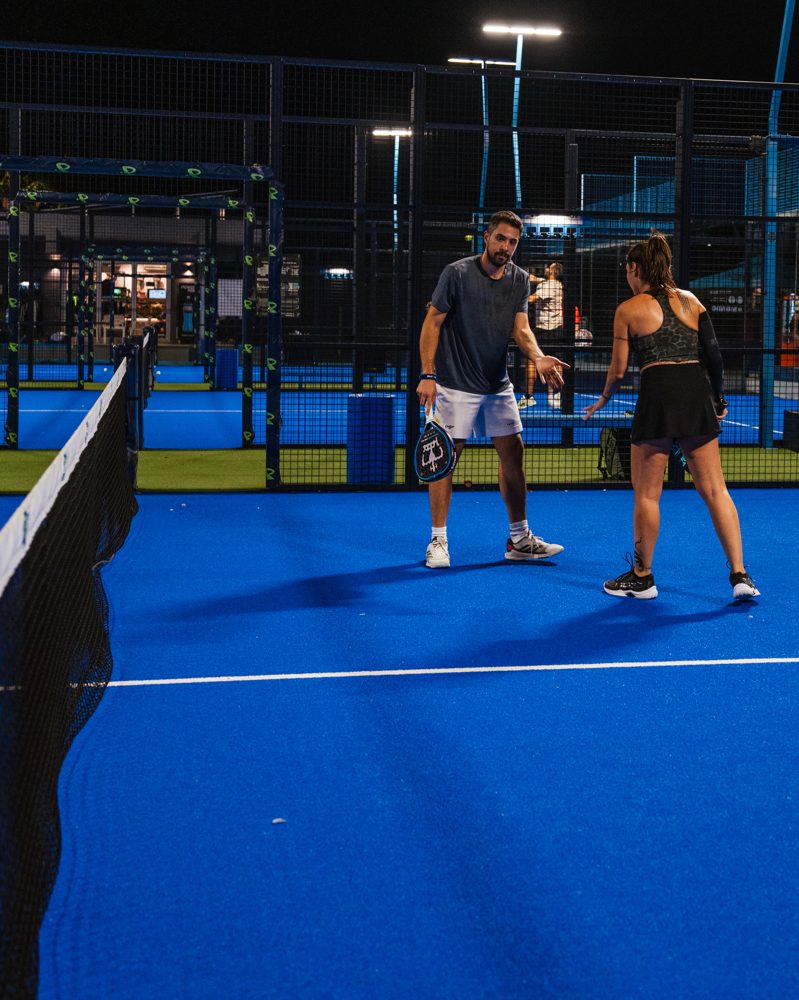 Coach talking tactics with a player at the net